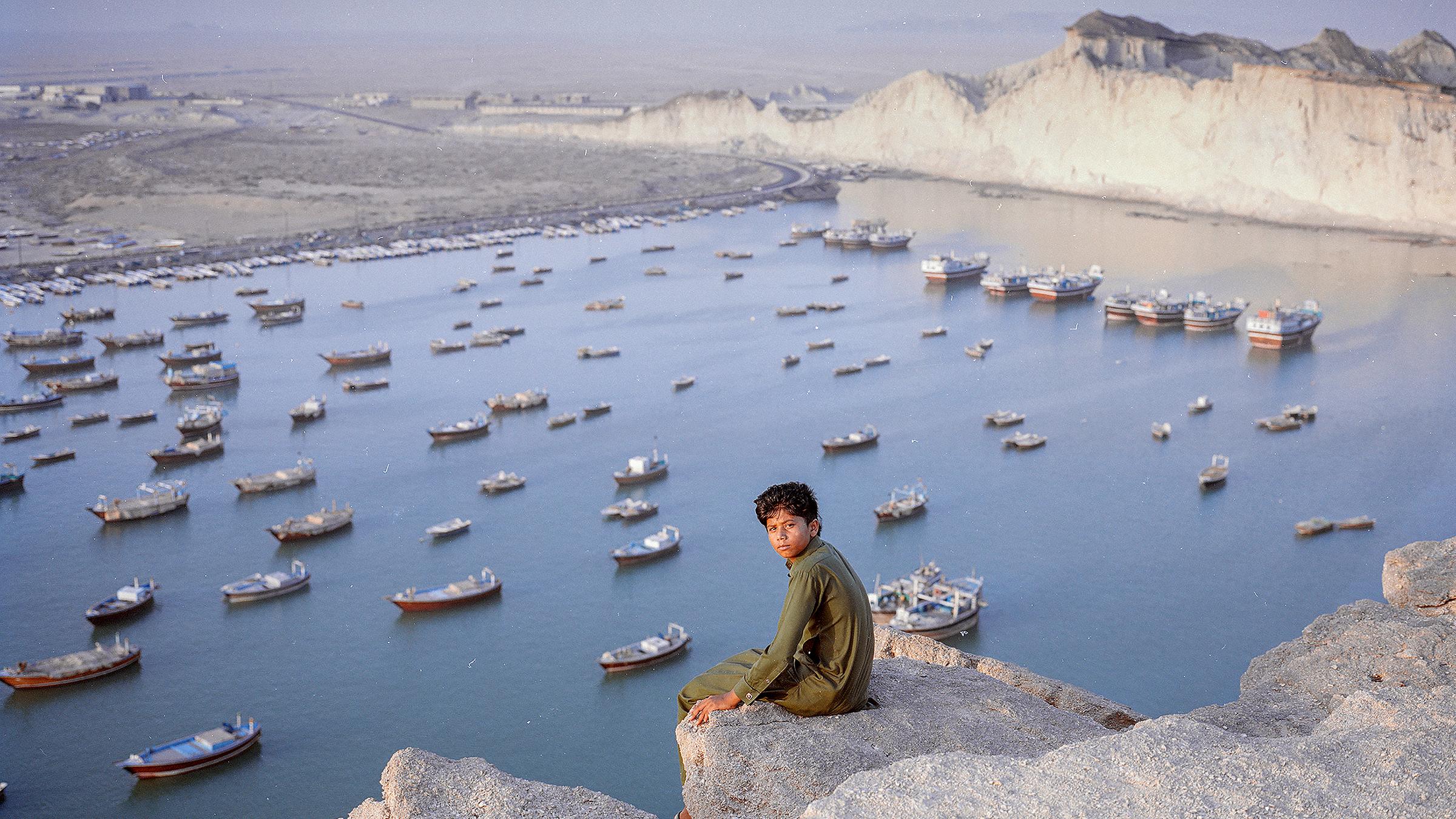 Der 13-jährige Hossein sitzt vor dem Hamun-See im Iran.
