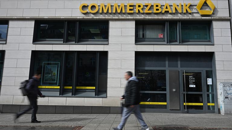 Hessen, Frankfurt/Main: Passanten gehen vor der Fassade einer Filiale der Commerzbank entlang.