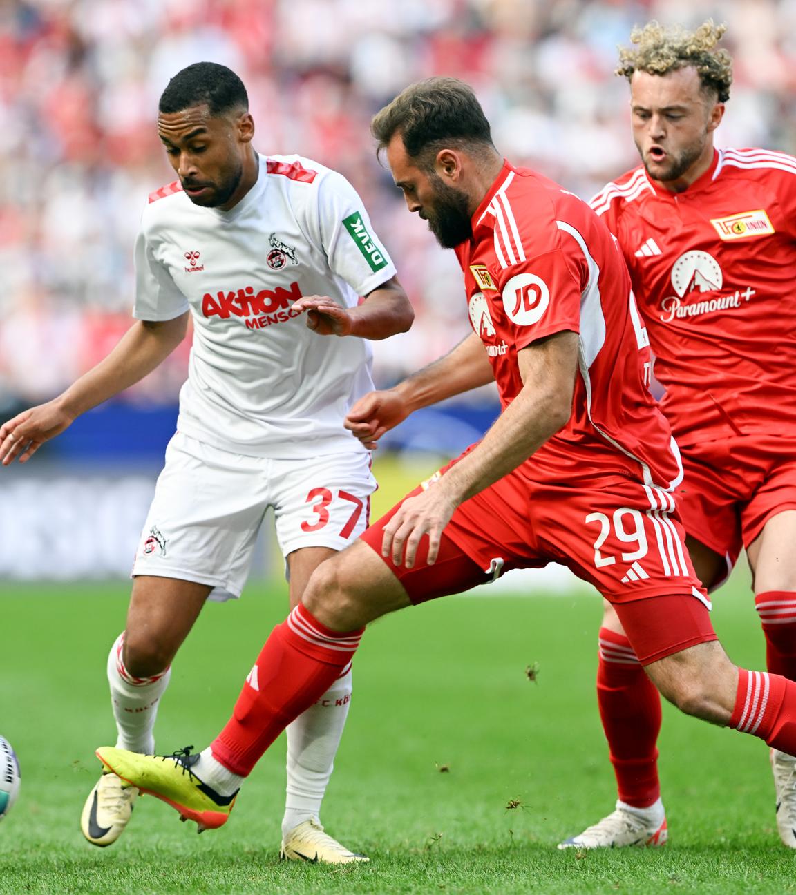 Kölns Linton Maina (l) und Berlins Lucas Tousart (M) und Benedict Hollerbach (r) kämpfen um den Ball.