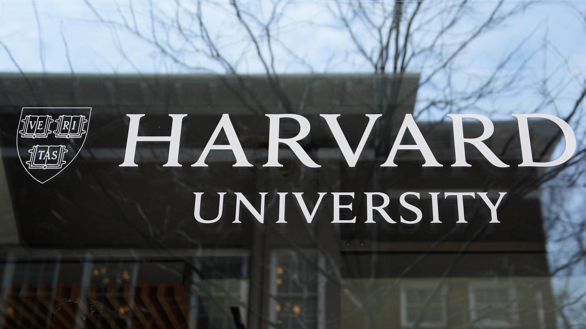 Symbolbild: Das Logo der Harvard University prangt an einem Gebäude der Hochschule