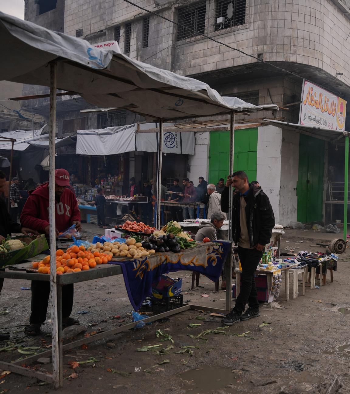 Ein belebter Markt in Gaza-Stadt, im Vordergrund ein Stand mit frischem Obst und Gemüse. 