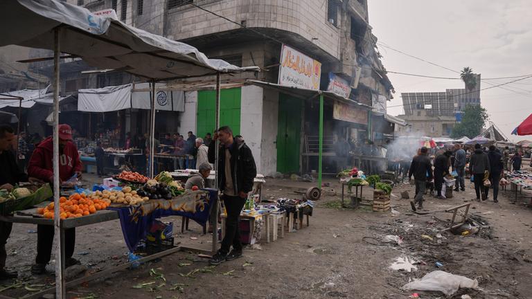 Ein belebter Markt in Gaza-Stadt, im Vordergrund ein Stand mit frischem Obst und Gemüse. 