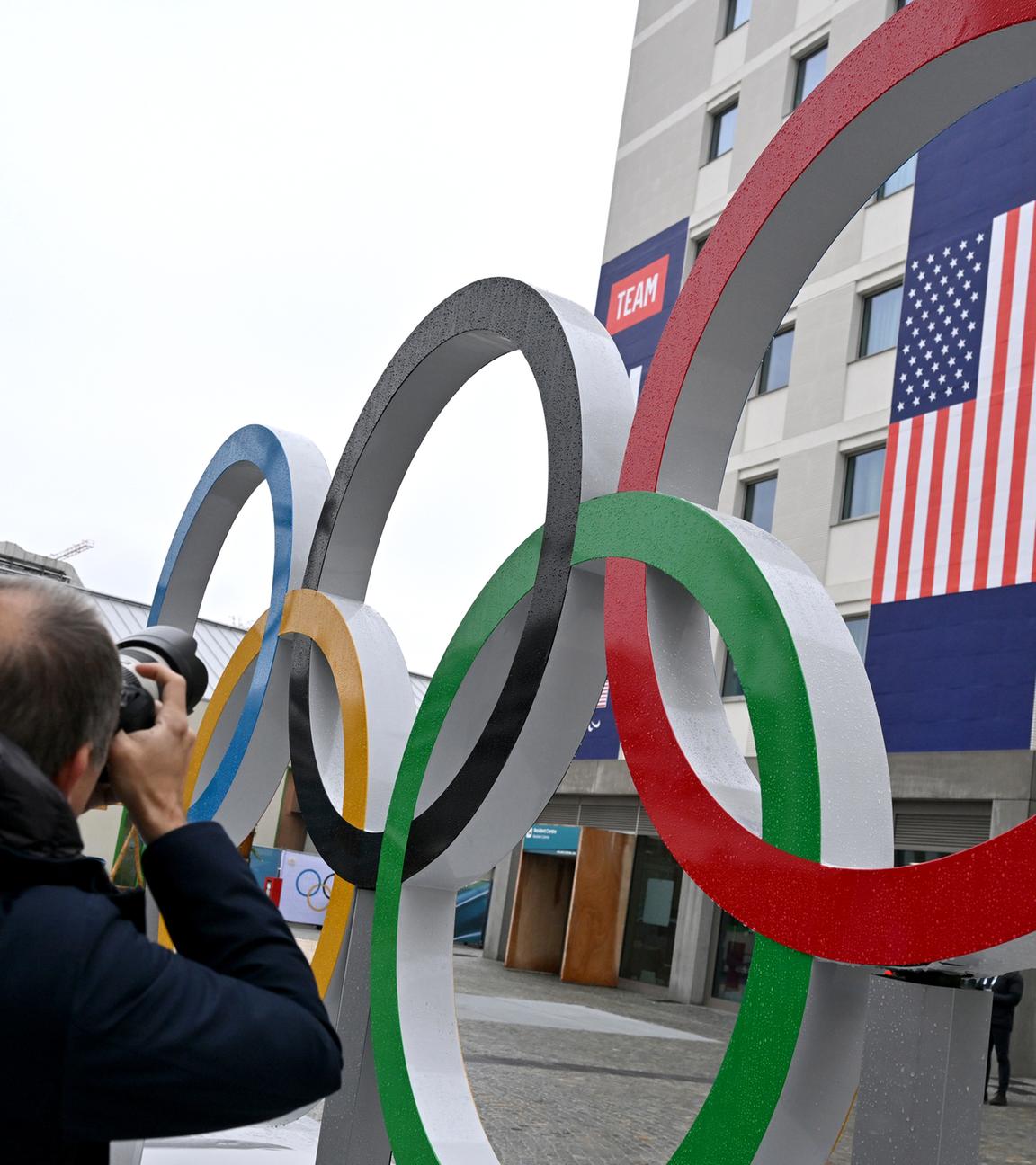 Ein Fotograf fotografiert die Olympischen Ringe und das Teamquartier der USA im Olympischen Dorf in Mailand
