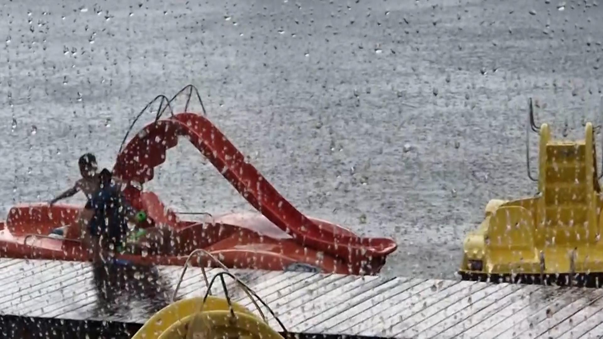 Bayern, Kinding: Kinder gehen vor Regen in Deckung. 