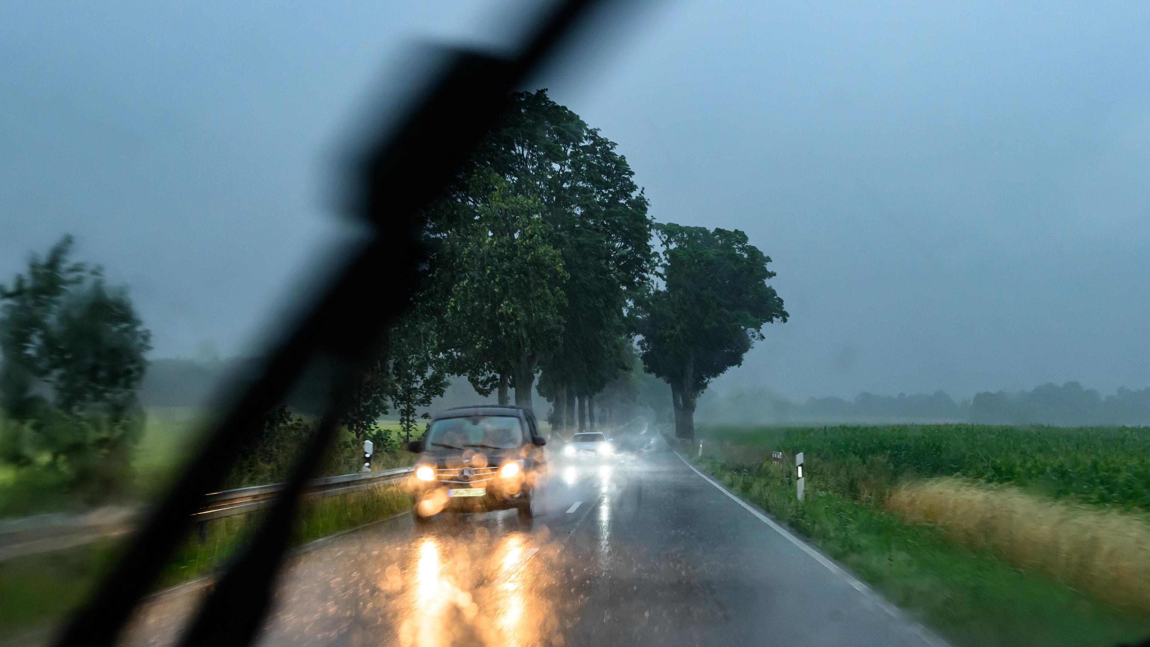  Beeskow: Während eines heftigen Regenschauers sind Autos auf einer Landstraße im östlichen Brandenburg unterwegs.