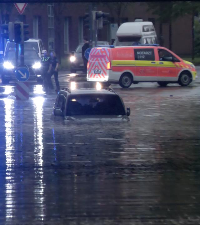 29.05.2026, Niedersachsen, Rheine: Ein Auto steht in einer überfluteten Straße in einer Unterführung. 