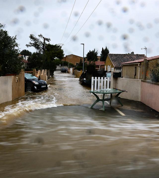 20.10.2026, Frankreich, Saint-Mitre-Les-Remparts: Diese Aufnahme mit langer Belichtungszeit zeigt eine überflutete Straße in einem Wohngebiet nach heftigen Regenfällen in der Nähe von Marseille im Südosten Frankreichs.