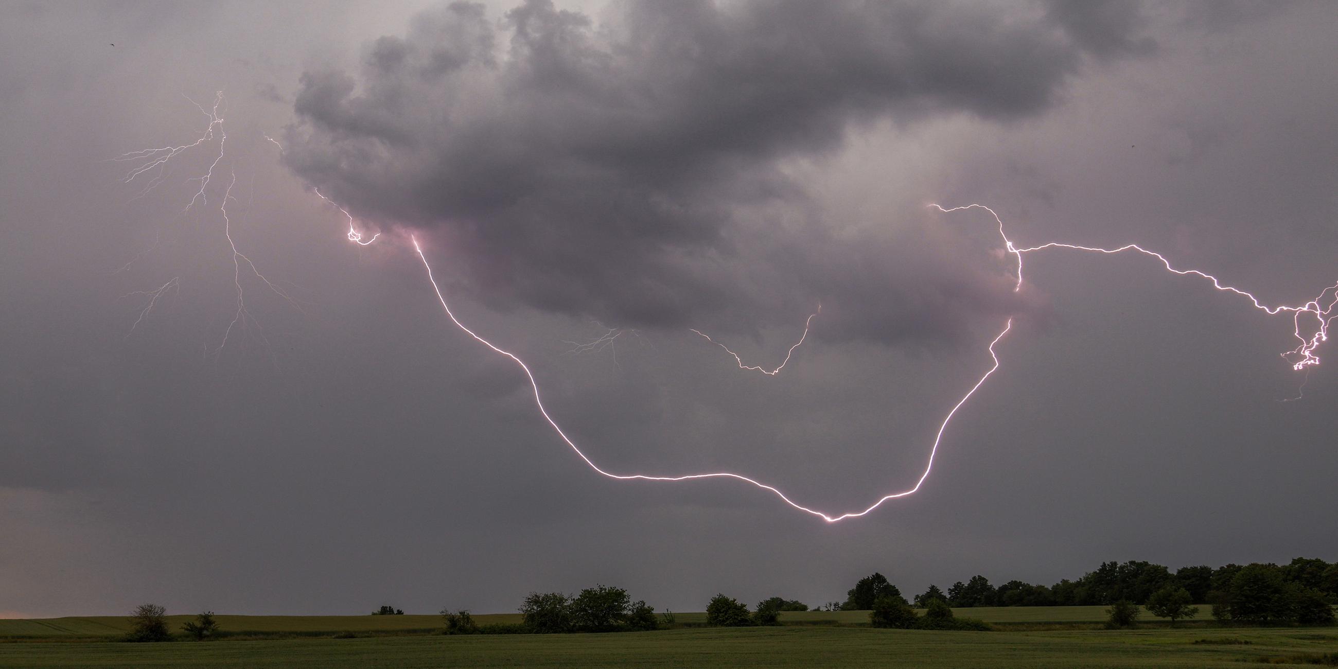 Der Blitz eines Gewitters ist am Nachmittag über einem Feld bei Oberursel-Oberstedten zu sehen. 