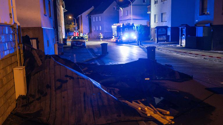 Einsatzkräfte der Feuerwehr stehen vor beschädigten Häusern. Aufgenommen am 20.08.2026, Hessen, Wetzlar