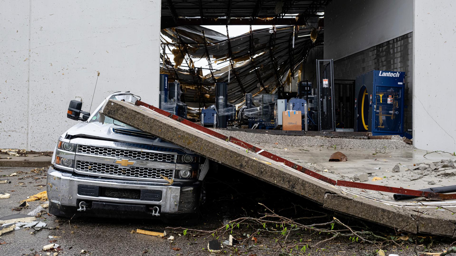 Ein beschädigter Lastwagen steht unter einem Teil einer eingestürzten Lagerhauswand, nachdem heftige Stürme und Tornados über das Gebiet zogen. Am 03.04.2025, in Jeffersontown, USA
