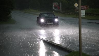 Auf einer Bundesstraße in Wuppertal fährt ein Auto am 19.06.2026 durch große Pfützen.
