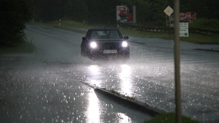 Auf einer Bundesstraße in Wuppertal fährt ein Auto am 19.06.2026 durch große Pfützen.