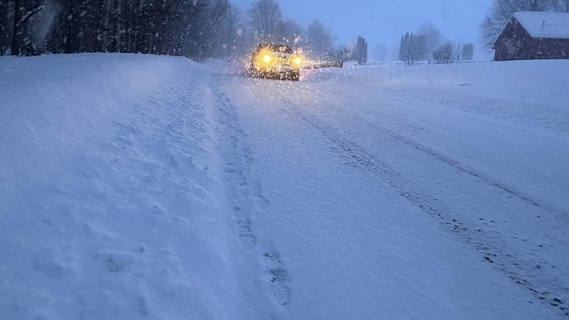Ein Auto fährt über eine verschneite Straße im amerikanischen Lowville, New York, am 22.01.2026.