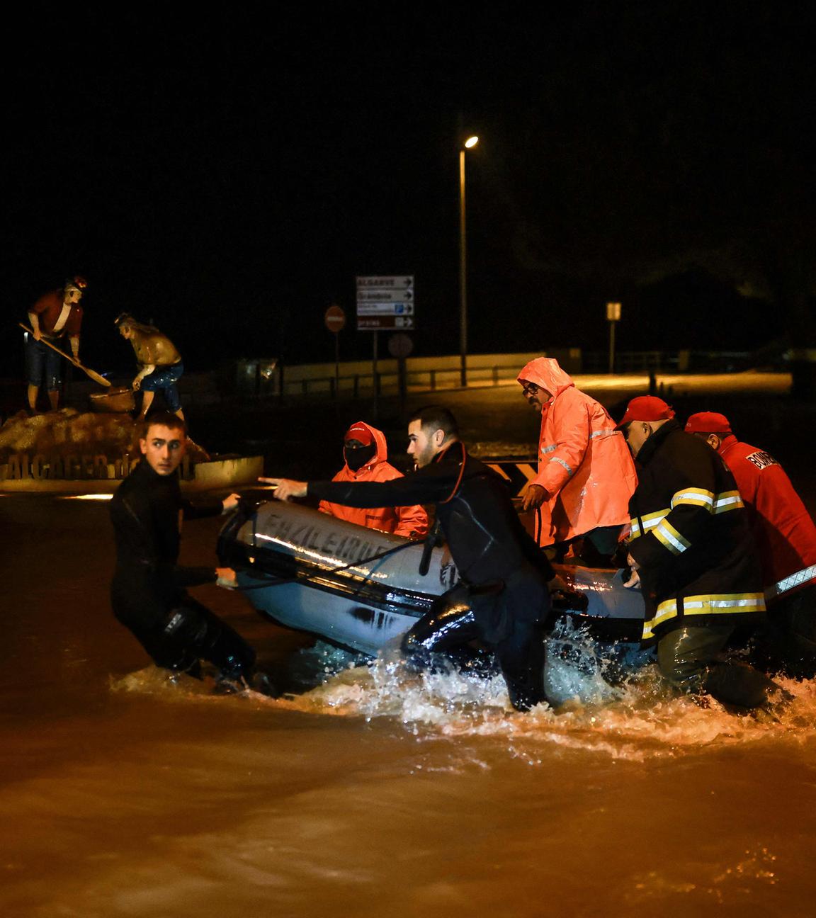 Feuerwehrleute ziehen ein Schlauchboot aus den Fluten des Flusses Sado, die am 4. Februar 2026 in Alcácer do Sal im Süden Portugals während des Sturms Leonardo die Straßen überschwemmten. 