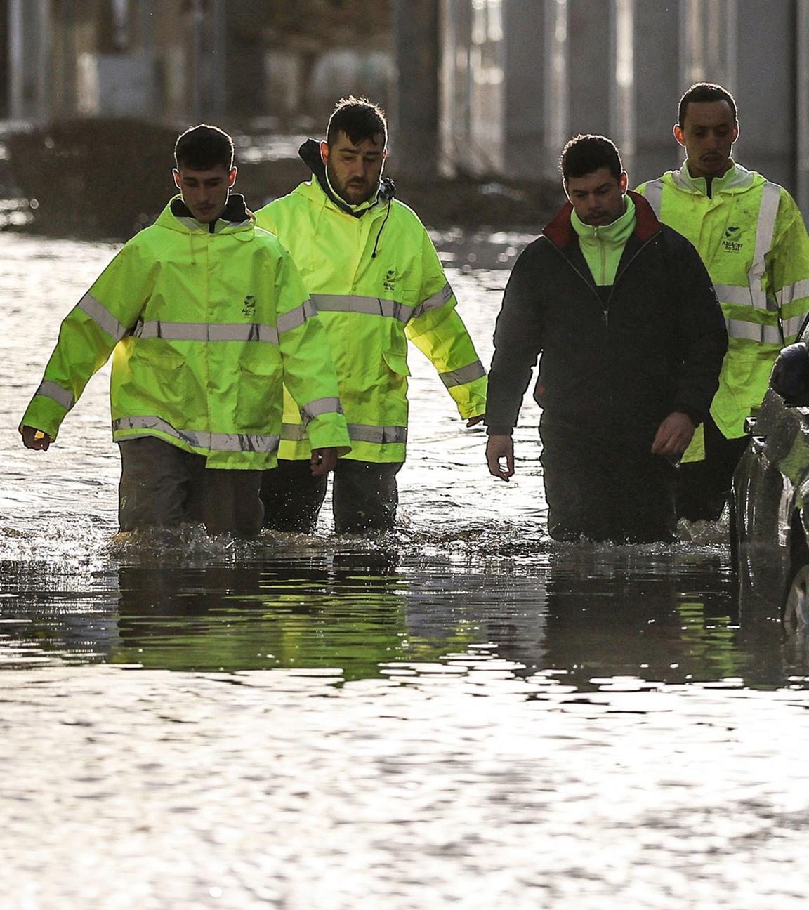 Mitarbeiter des Rathauses waten durch Hochwasser, das während des Sturms Leonardo am 5. Februar 2026 eine Straße in Alcácer do Sal im Süden Portugals überschwemmt.
