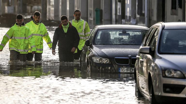 Mitarbeiter des Rathauses waten durch Hochwasser, das während des Sturms Leonardo am 5. Februar 2026 eine Straße in Alcácer do Sal im Süden Portugals überschwemmt.