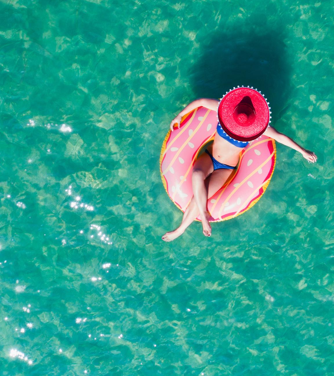 Frau sitzt in einem Luftkissen im Pool