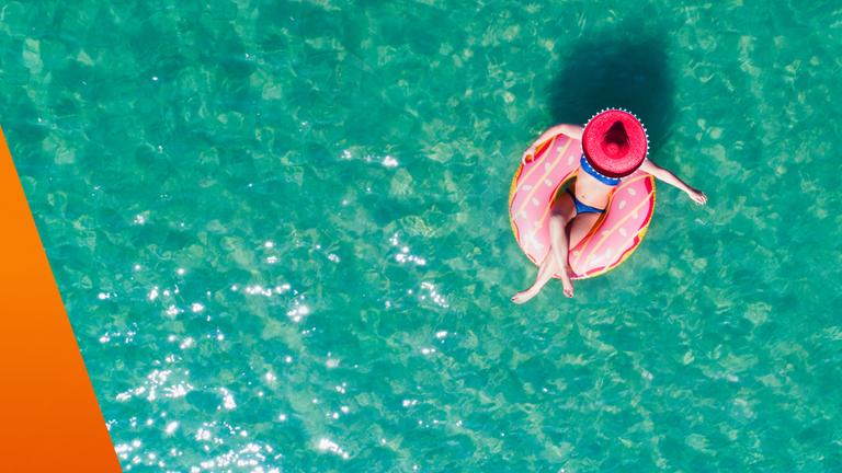 Frau sitzt in einem Luftkissen im Pool