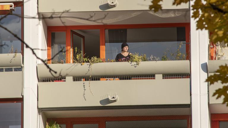 Eine Frau steht auf ihrem Balkon