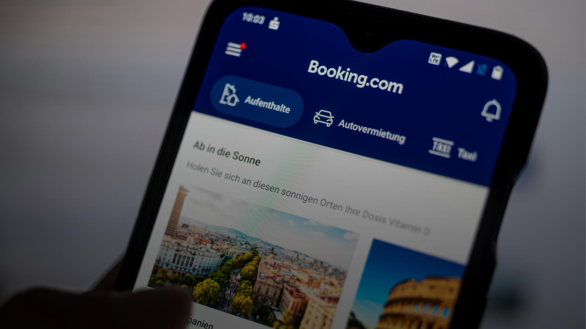 Auf einem Smartphone ist die App des Reiseportals Booking.com zu sehen.