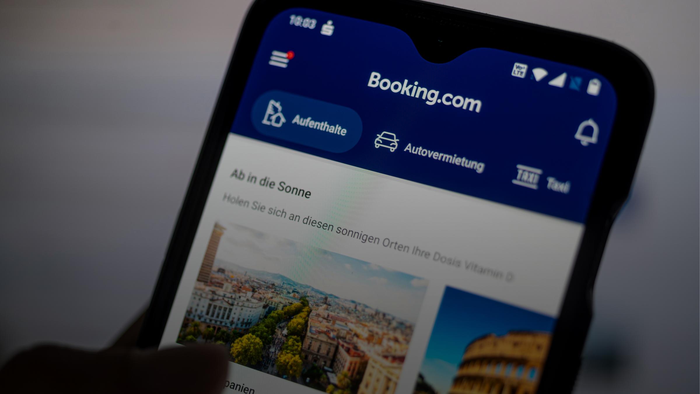 Auf einem Smartphone ist die App des Reiseportals Booking.com zu sehen.
