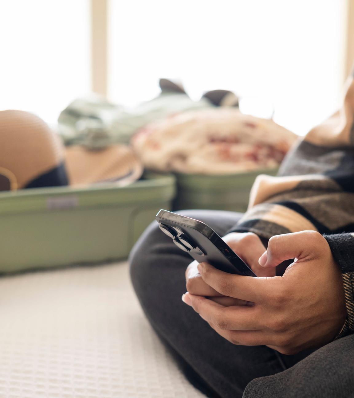 Ein offener Urlaubskoffer liegt auf dem Hotelbett