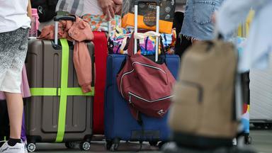  Flugreisende warten mit ihrem Gepäck am Check-In im Flughafen Leipzig-Halle