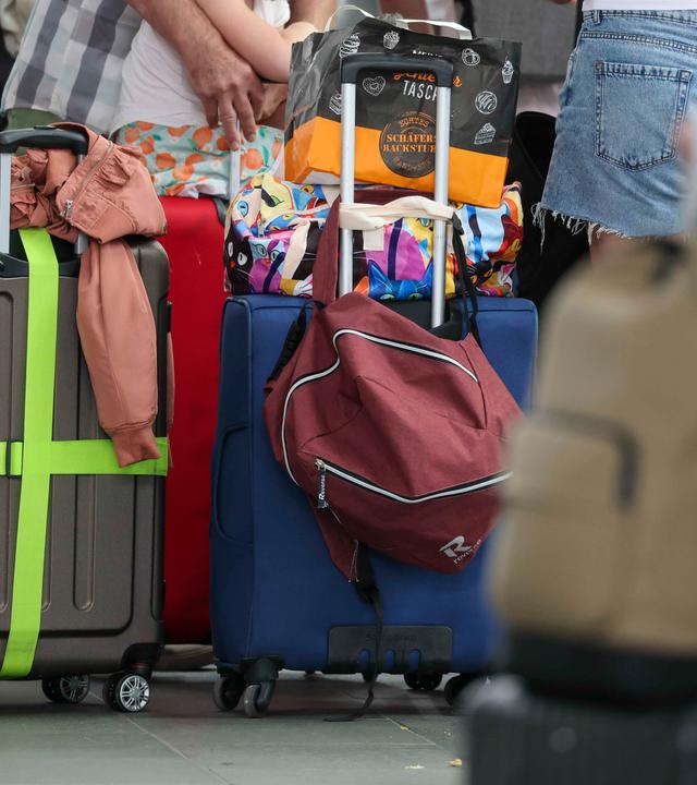  Flugreisende warten mit ihrem Gepäck am Check-In im Flughafen Leipzig-Halle