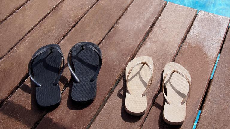 Zwei Paar Flipflops am Pool