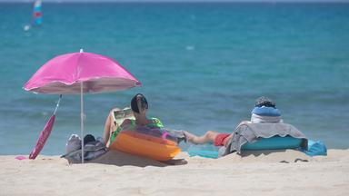 Menschen sonnen sich am Strand von Arenal auf Mallorca