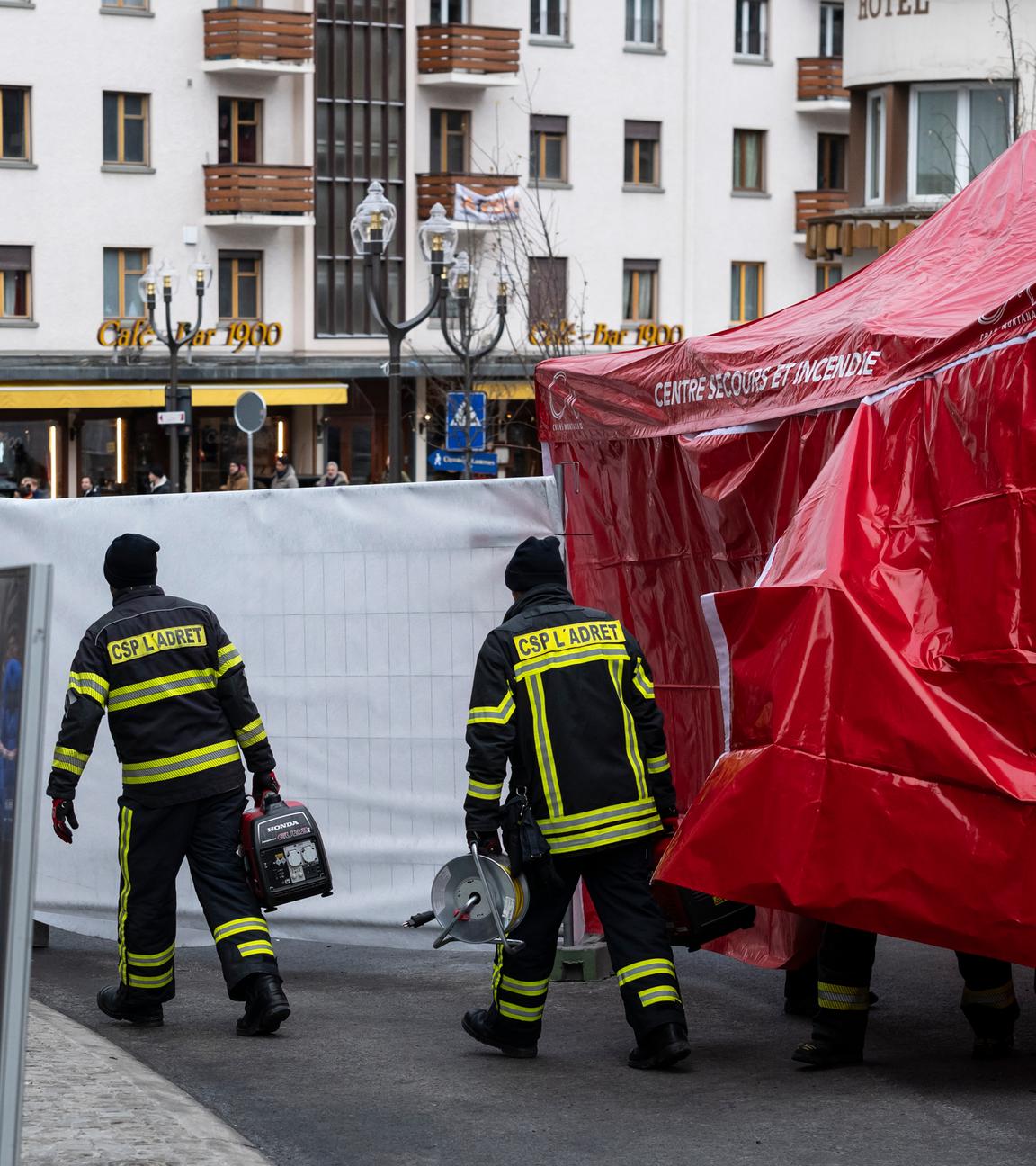 Feuerwehrleute verlassen das Schutzzelt vor der Bar und Lounge «Le Constellation», in der während der Silvesterfeierlichkeiten ein Feuer ausgebrochen ist.