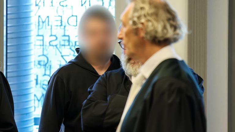 Der Angeklagte Daniel S. (l) steht vor Verhandlungsbeginn hinter seinen Anwälten. 