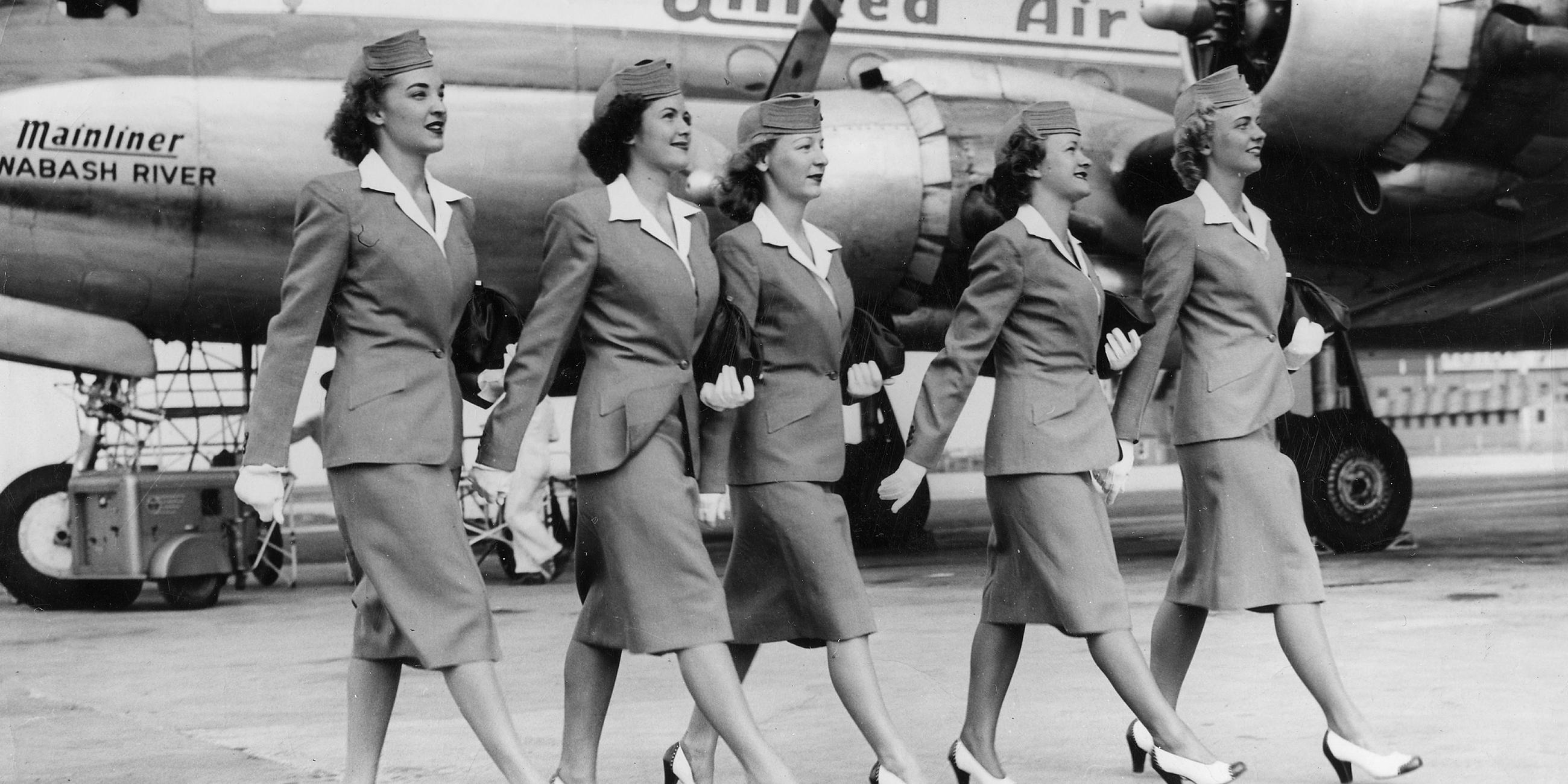 US-Amerikanische Stewardessen laufen über das Flugfeld zu ihrer Maschine