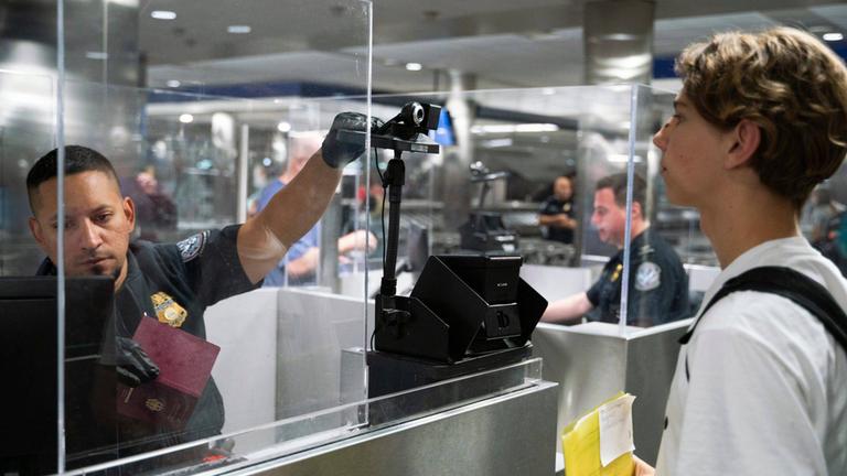 Beamter von Customs and Border Protection (CBP), J. Jimenez, fotografiert Luis Hubner, einen aus Deutschland ankommenden Reisenden, mithilfe biometrischer Gesichtserkennung beim Betreten des US-Zoll- und Grenzschutzes am McNamara-Terminal des Detroit Metro Airport in Romulus