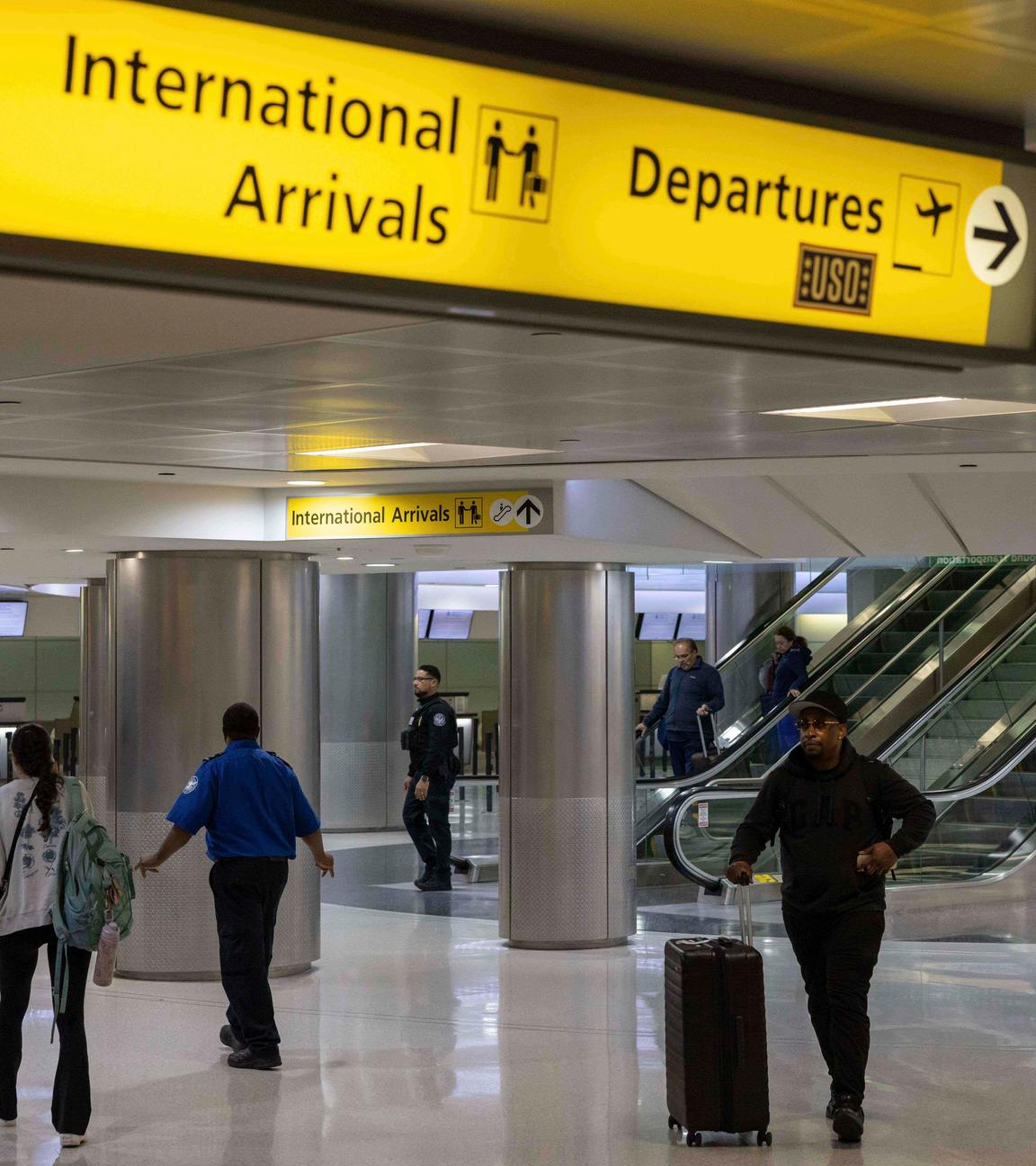 Menschen mit Koffern gehen durch das internationale Terminal des Newark Liberty International Airport.