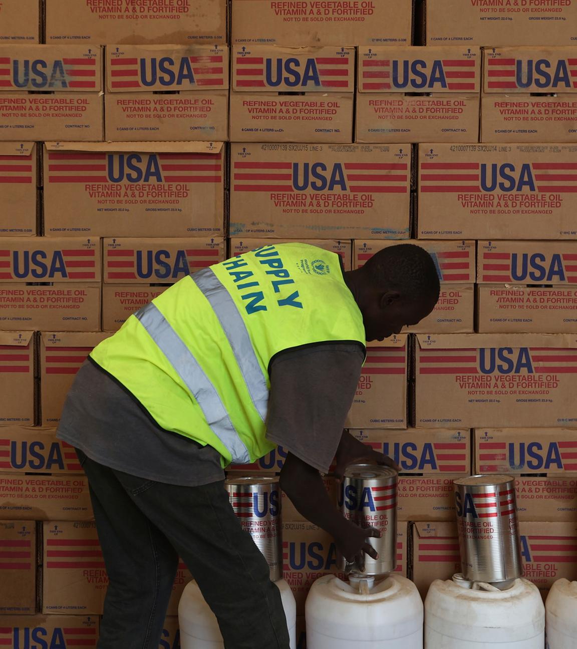 Ein Mann sortiert in einer Lagerhalle Hilfsgüter von der Amerikanischen Entwicklungshilfe Organisation USAID.