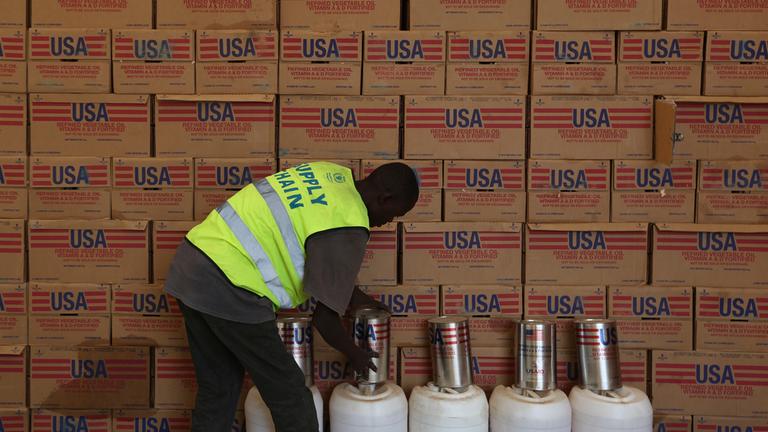 Ein Mann sortiert in einer Lagerhalle Hilfsgüter von der Amerikanischen Entwicklungshilfe Organisation USAID.