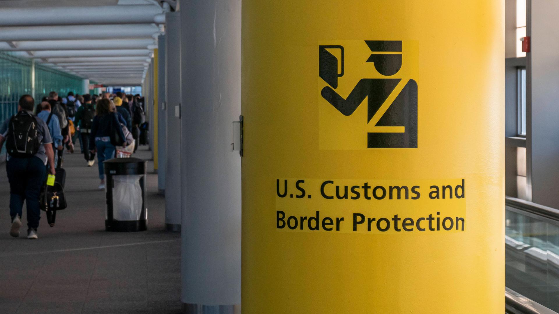 Symbolbild: Schild der US Grenzbehörde mit dem Symbol des U.S. Customs and Border Protection (CBP) Schild, Aufschrift und Symbol auf gelbem Hintergrund im Newark Liberty International Airport, New York, USA