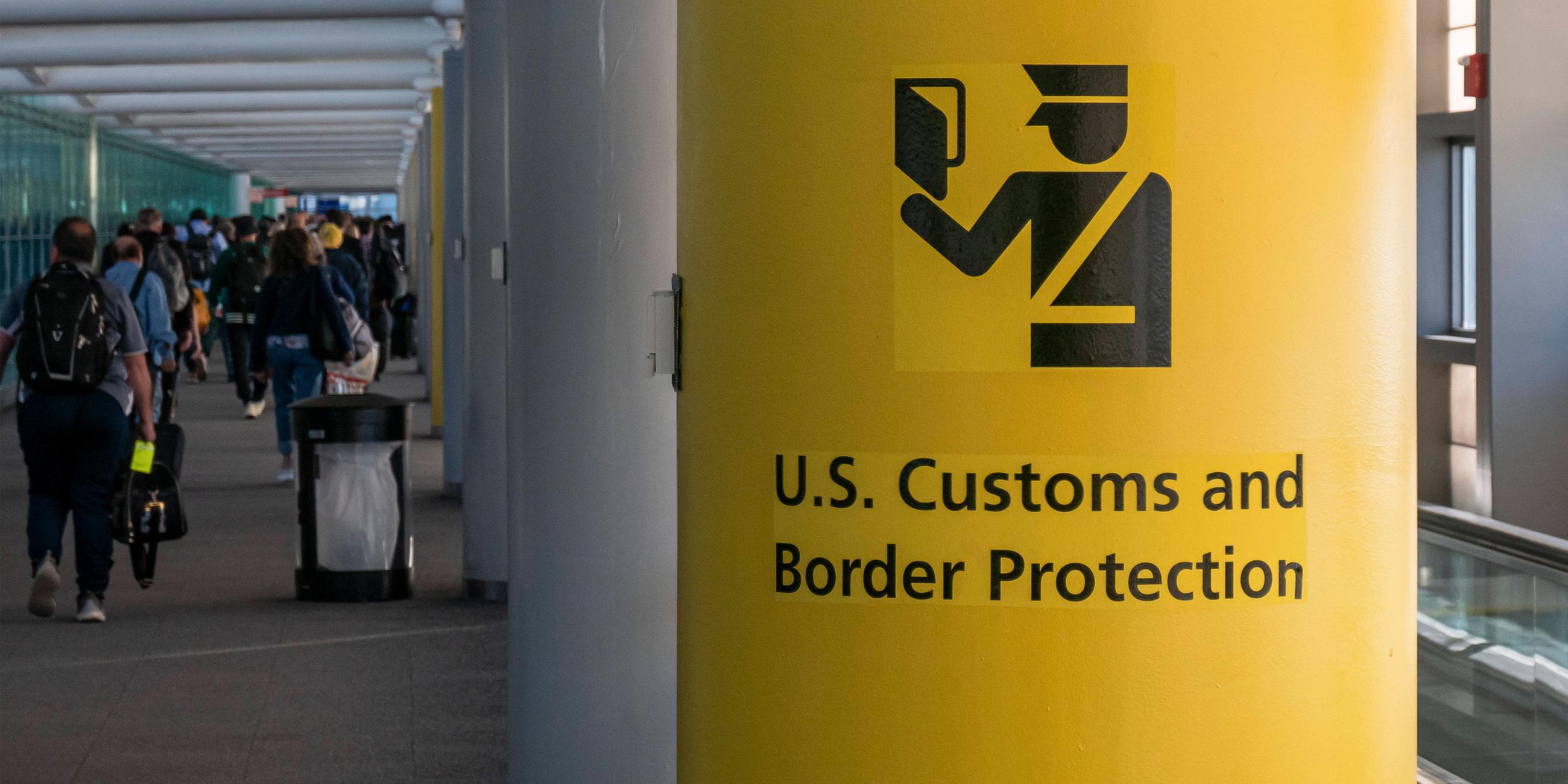 Symbolbild: Schild der US Grenzbehörde mit dem Symbol des U.S. Customs and Border Protection (CBP) Schild, Aufschrift und Symbol auf gelbem Hintergrund im Newark Liberty International Airport, New York, USA