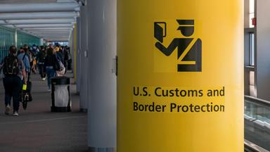 Symbolbild: Schild der US Grenzbehörde mit dem Symbol des U.S. Customs and Border Protection (CBP) Schild, Aufschrift und Symbol auf gelbem Hintergrund im Newark Liberty International Airport, New York, USA