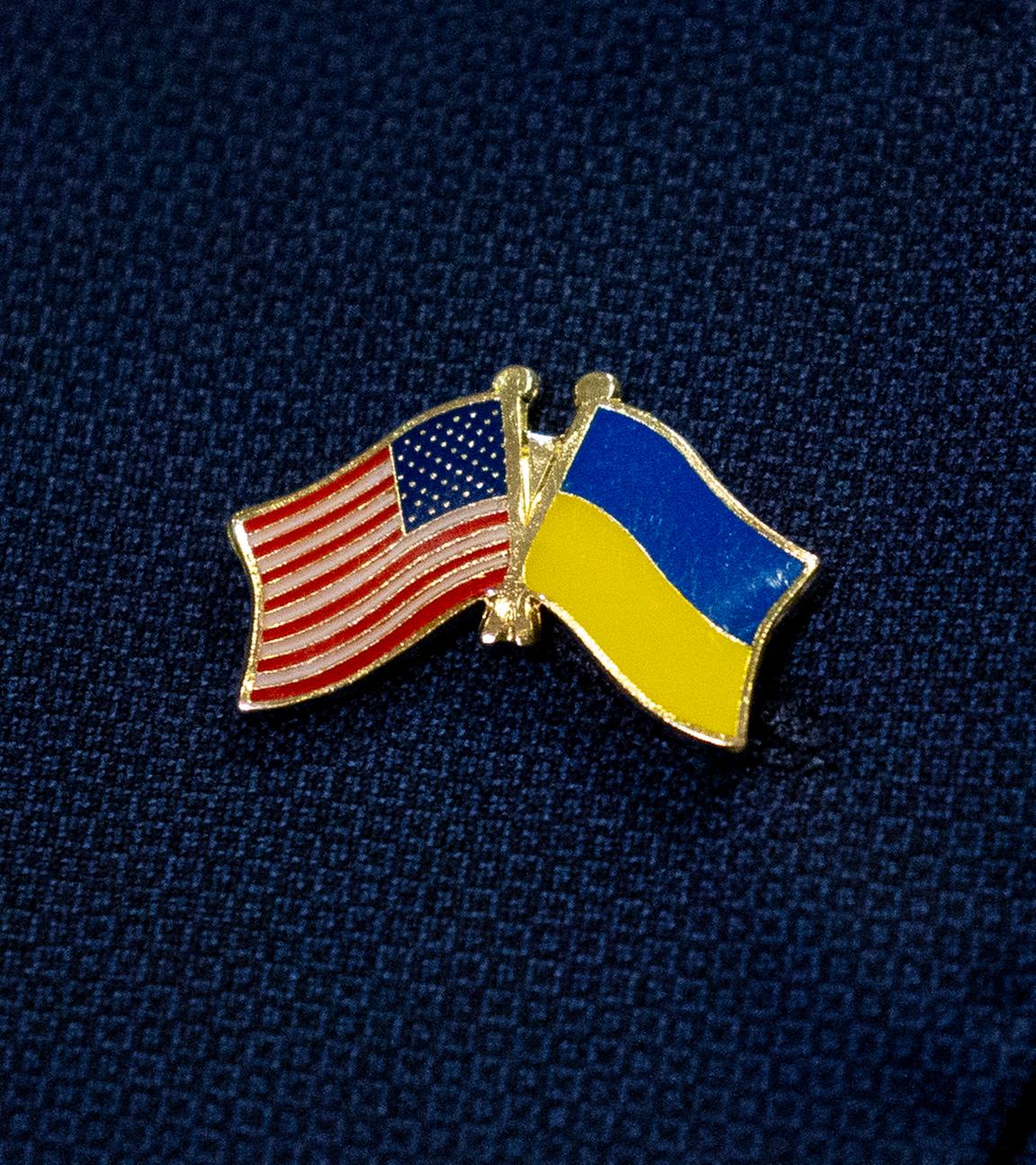 Ein Pin mit der US-amerikanischen und der ukrainischen Nationalflagge ist zu sehen.