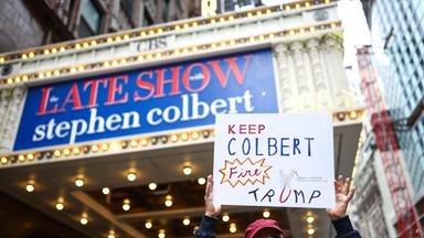 Ein Mann hält am 21. Mai 2026 vor dem Ed Sullivan Theater in New York ein Schild in die Höhe – kurz vor der Aufzeichnung der letzten Folge der „Late Show“. 