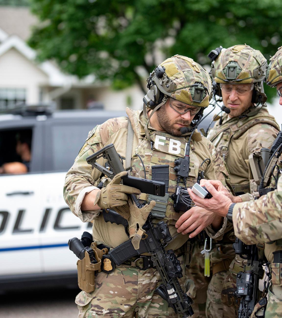 Bewaffnete FBI-Agenten treffen sich in der Nähe des Hauses von Melissa Hortman in Brooklyn Park, um Strategien für die Suche nach einem aktiven Schützen zu entwickeln
