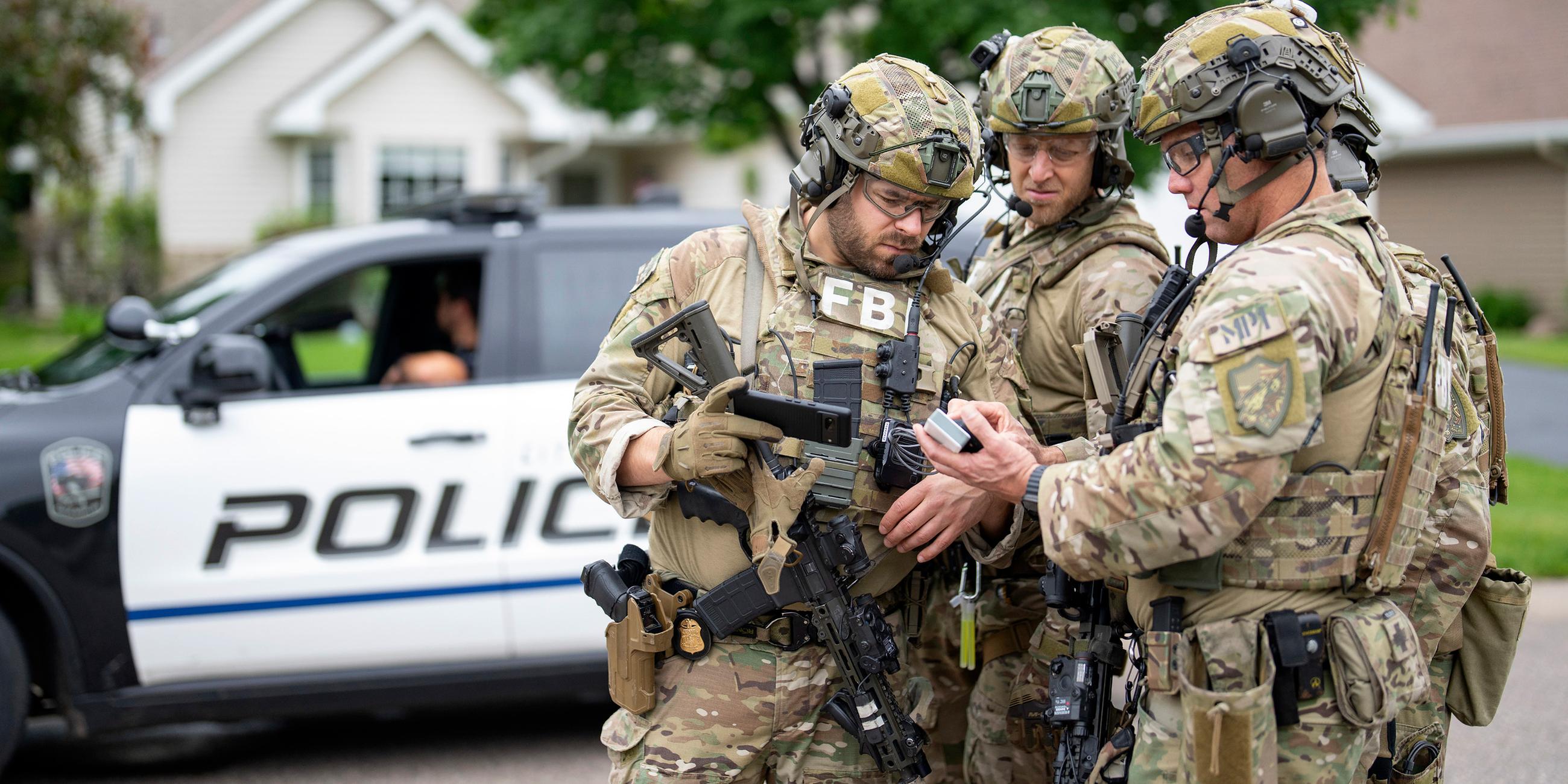 Bewaffnete FBI-Agenten treffen sich in der Nähe des Hauses von Melissa Hortman in Brooklyn Park, um Strategien für die Suche nach einem aktiven Schützen zu entwickeln