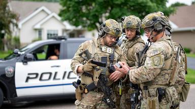 Bewaffnete FBI-Agenten treffen sich in der Nähe des Hauses von Melissa Hortman in Brooklyn Park, um Strategien für die Suche nach einem aktiven Schützen zu entwickeln