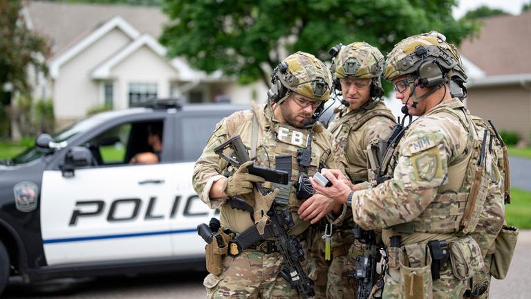 Bewaffnete FBI-Agenten treffen sich in der Nähe des Hauses von Melissa Hortman in Brooklyn Park, um Strategien für die Suche nach einem aktiven Schützen zu entwickeln