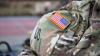 Ein Aufnäher in Form der US-Flagge ist an der Uniform eines US-Soldaten angebracht.