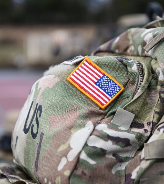 Ein Aufnäher in Form der US-Flagge ist an der Uniform eines US-Soldaten angebracht.
