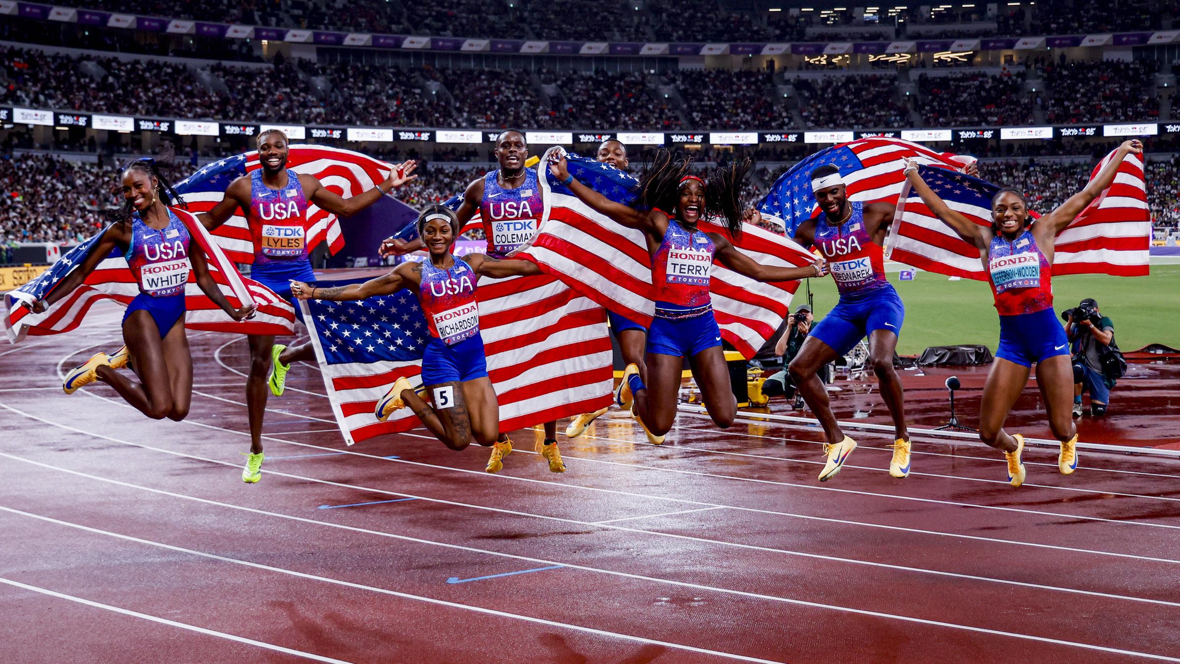 Die Frauen und Männer der US-Sprintstaffeln feiern gemeinsam den Gewinn ihres WM-Titels.