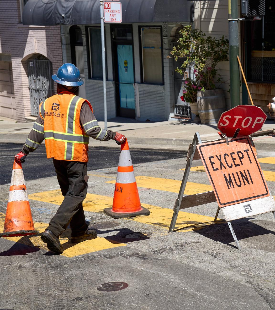 14. Juni 2024: Ein Bauarbeiter in Sicherheitskleidung platziert Warnkegel auf einer gesperrten Straße, um den Verkehr umzuleiten in San Francisco, USA.
